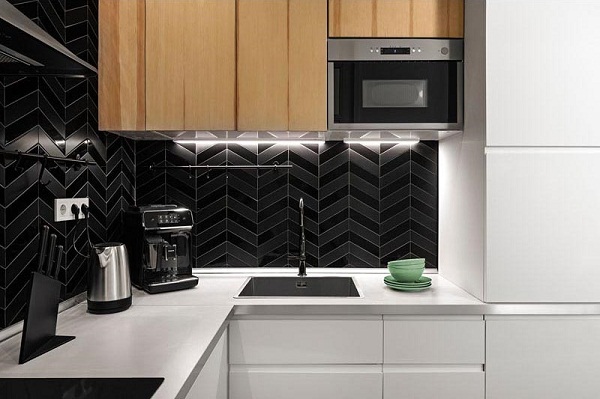 Hình ảnh phòng bếp với tường ốp gạch đen, tủ màu trắng kết hợp chất liệu gỗ ấm áp