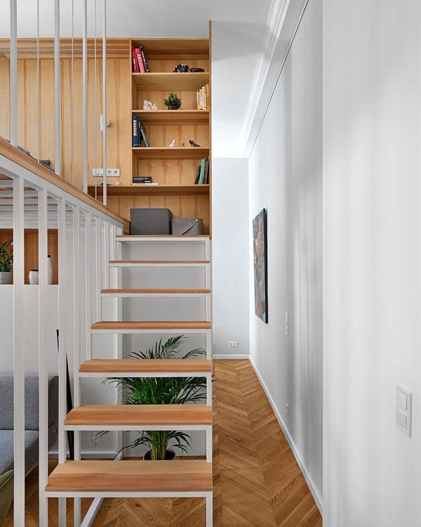 Hình ảnh cầu thang bậc hở dẫn lên gác lửng được thiết kế liền khối với tủ sách phía trên