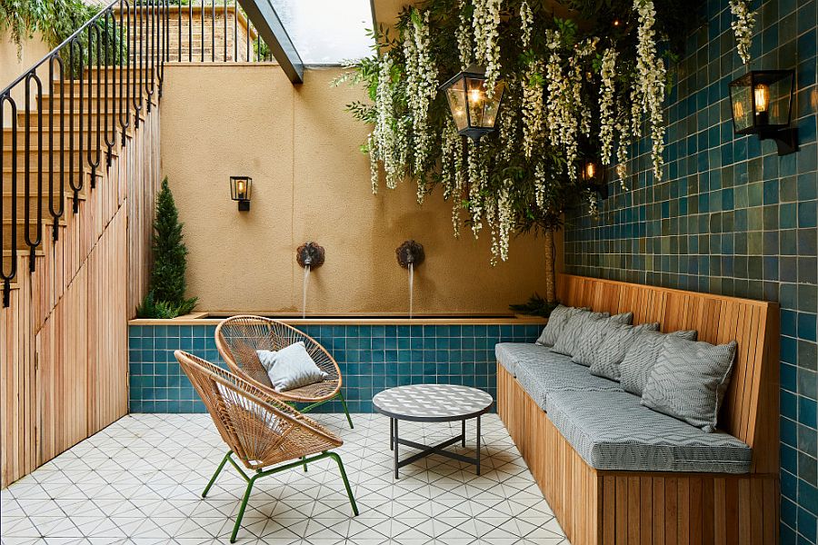 Hình ảnh không gian thư giãn ngoài trời với ghế sofa, tường ốp gạch, cây xanh trang trí, cầu thang