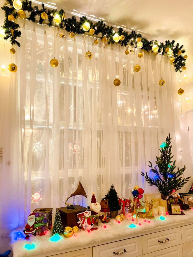 Hình ảnh khung cửa sổ với rèm cửa màu trắng, đèn trang trí, cây thông, ông già Noel