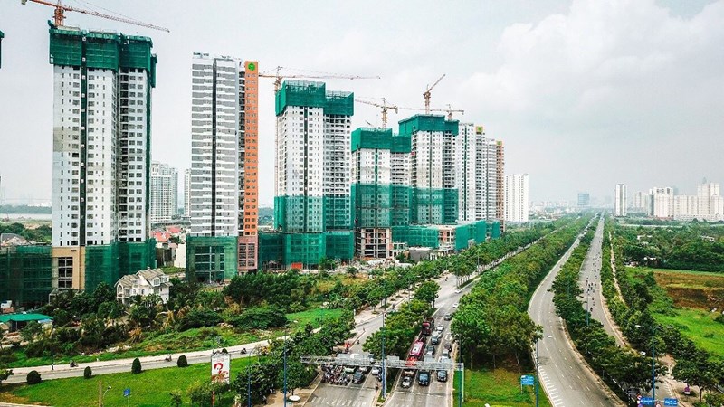 Hình ảnh những tòa nhà cao tầng đang trong quá trình xây dựng, đường sá rộng rãi, hai bên trồng cây xanh