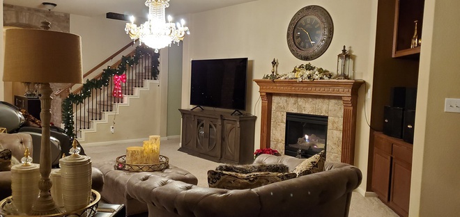 Hình ảnh phòng khách biệt thự của Quách Thành Danh với sofa nâu, lò sưởi, tivi, cạnh đó là cây thông trang trí Giáng sinh