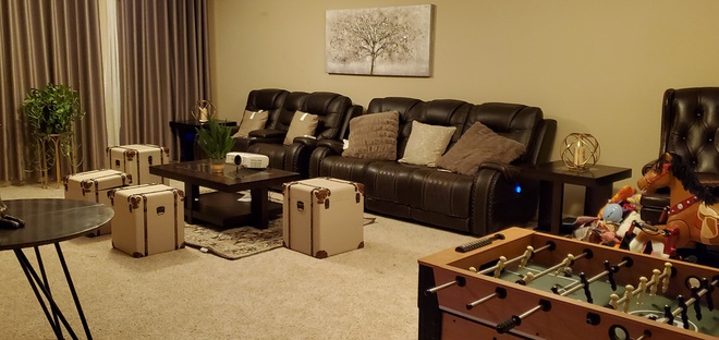 Hình ảnh một góc phòng khách với sofa nâu đậm, ghế đơn độc đáo, bàn trà nhỏ, trò chơi bi lắc