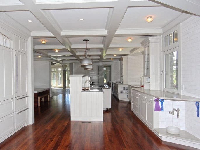 Hình ảnh phòng bếp rộng rãi với tông trắng chủ đạo, sàn nhà cánh gián