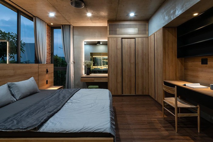 Hình ảnh phòng ngủ chính với nội thất gỗ chủ đạo, trần ốp gỗ, cửa kính trong suốt, rèm cửa màu xám nhạt