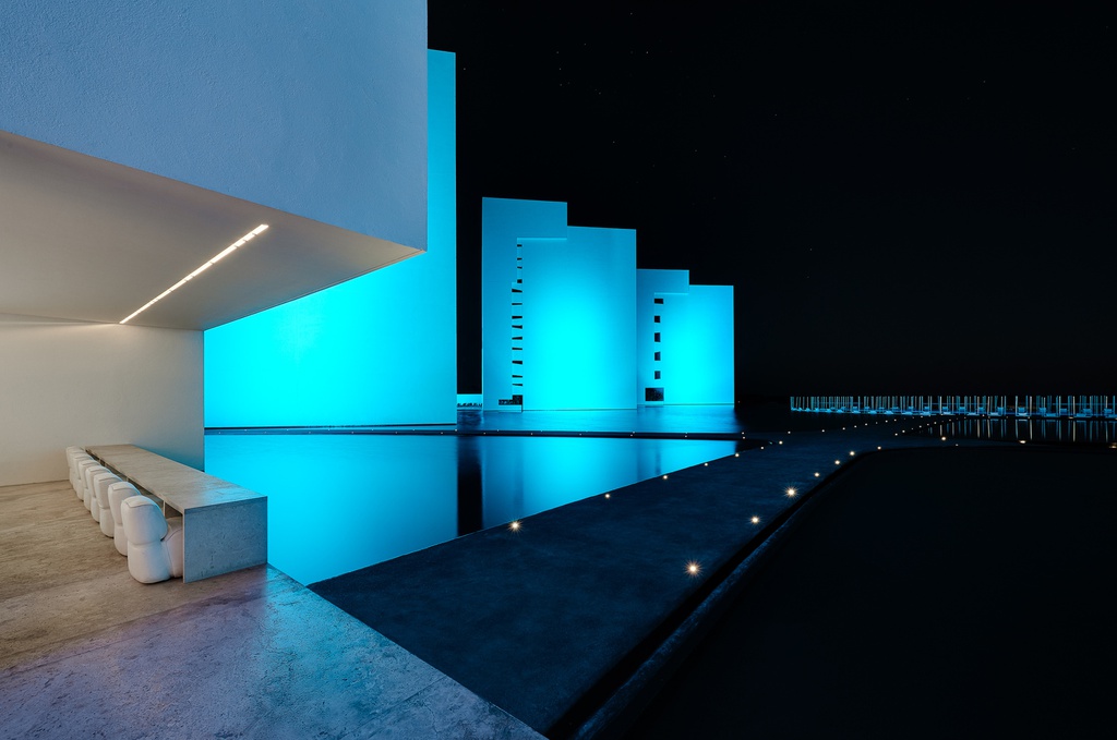 Hình ảnh ánh đèn phản chiếu mặt nước xung quanh khiến khách sạn tựa như viên ngọc màu xanh giữa lòng sa mạc