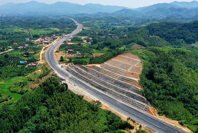 Hình ảnh một đoạn cao tốc Bắc Giang - Lạng Sơn nhìn từ trên cao với hai bên là cây cối, ruộng đồng, khu dân cư thưa thớt