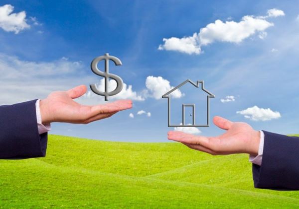 Hình ảnh hai cánh tay đang nâng đỡ mô hình ngôi nhà và đồng tiền USD, phông nền là trời xanh, thảm cỏ xanh mướt