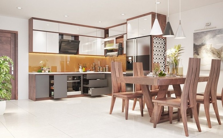 Hình ảnh toàn cảnh phòng bếp với bàn ghế ăn bằng gỗ tự nhiên, tủ bếp kết hợp ngăn kéo, tường chắn màu vàng, đèn thả trang trí