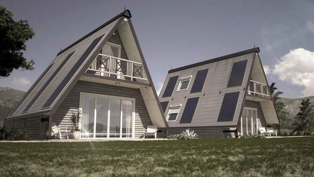 Hình ảnh toàn cảnh ngôi nhà lắp ráp trong 6 tiếng đồng hồ với phần mái màu xám, xanh than chủ đạo, tọa lạc trên thảm cỏ xanh mát