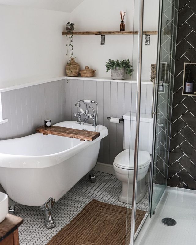 Hình ảnh cận cảnh phòng tắm với bồn tắm lớn màu tắm, khay gỗ đặt phía trên, cây xanh trang trí