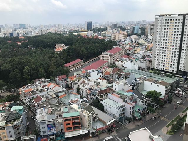 Hình ảnh một góc thành phố nhìn từ trên cao với những tòa nhà cao tầng xen kẽ khu dân cư thấp tầng, cây xanh