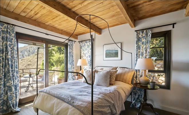 Hình ảnh phòng ngủ với giường sắt Retro, trần ốp gỗ, rèm hoa màu xanh, cửa sổ kính 