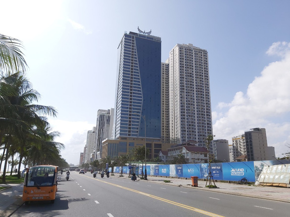 Hình ảnh toàn cảnh dự án Tổ hợp khách sạn Mường Thanh và căn hộ chung cư cao cấp Sơn Trà bên cạnh đường nhựa nhiều xe cộ qua lại hàng dừa xanh mát