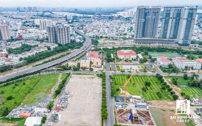 Hình ảnh một góc thành phố nhìn từ trên cao với nhiều tòa nhà cao tầng xen kẽ khu dân cư thấp tầng, cây xanh, lô đất trống