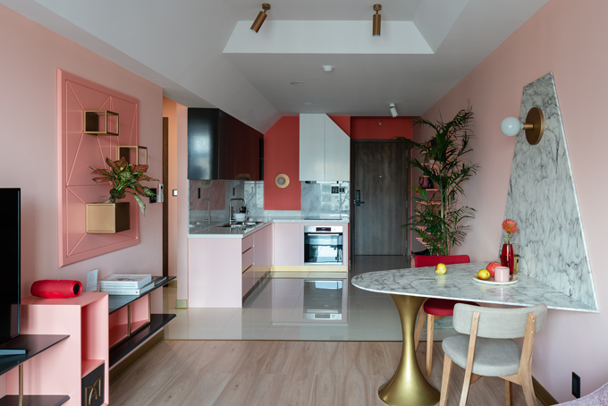 Hình ảnh toàn cảnh phòng khách, khu ăn uống trong căn hộ của Mai Anh với trần thạch cao chóp cụt, tường sơn hồng