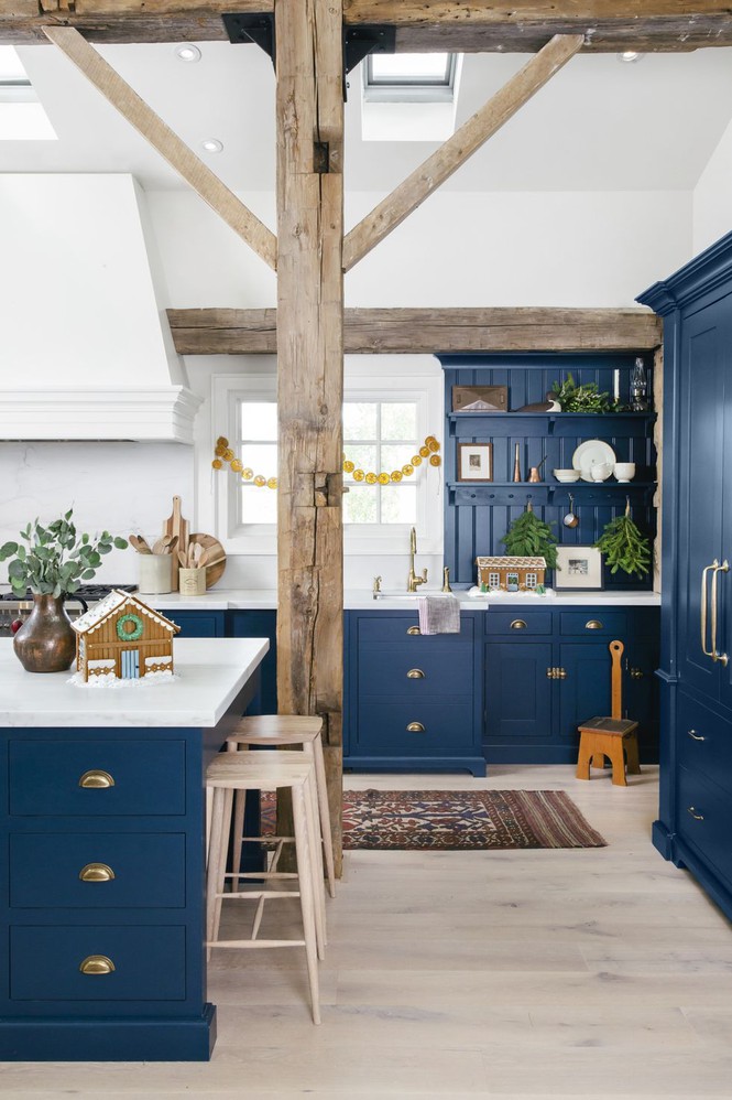 Hình ảnh phòng bếp được bài trí hiện đại và sang trọng với hệ tủ lưu trữ màu xanh than, tay nắm mạ đồng sáng bóng