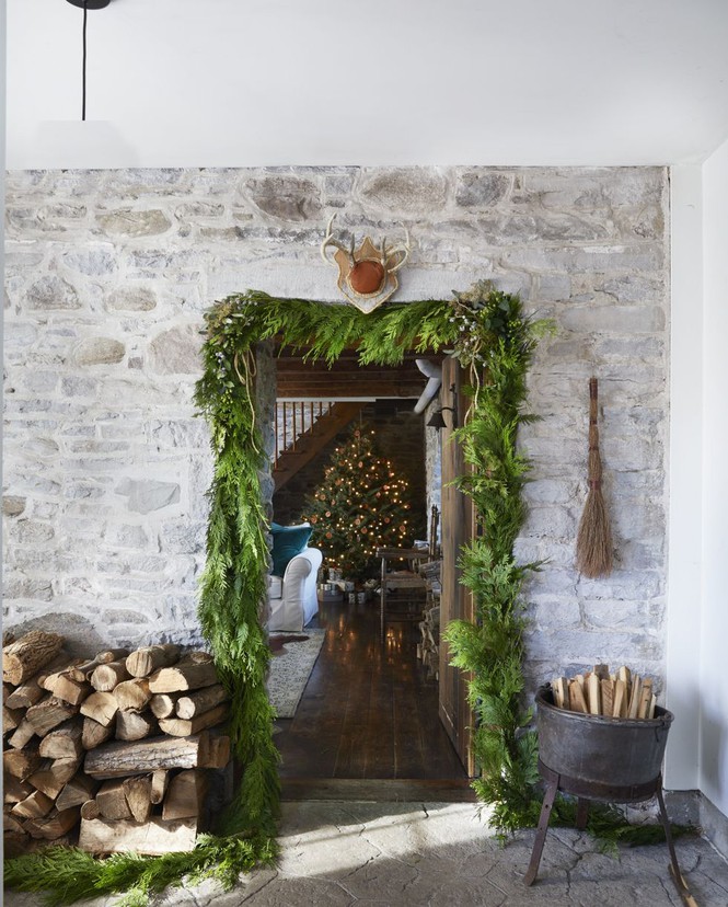 Hình ảnh cửa ra vào được trang trí bằng nguyệt quế, củi khô, bên trong là cây thông Noel