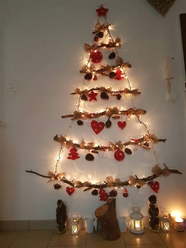 Hình ảnh cây thông Noel tượng trưng làm từ các nhánh cây, đèn LED, trái tim đỏ, nơ màu be...