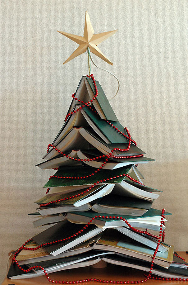 Hình ảnh chồng sách tạo hình cây thông Noel kết hợp với tràng hạt màu đỏ, ngôi sao vàng