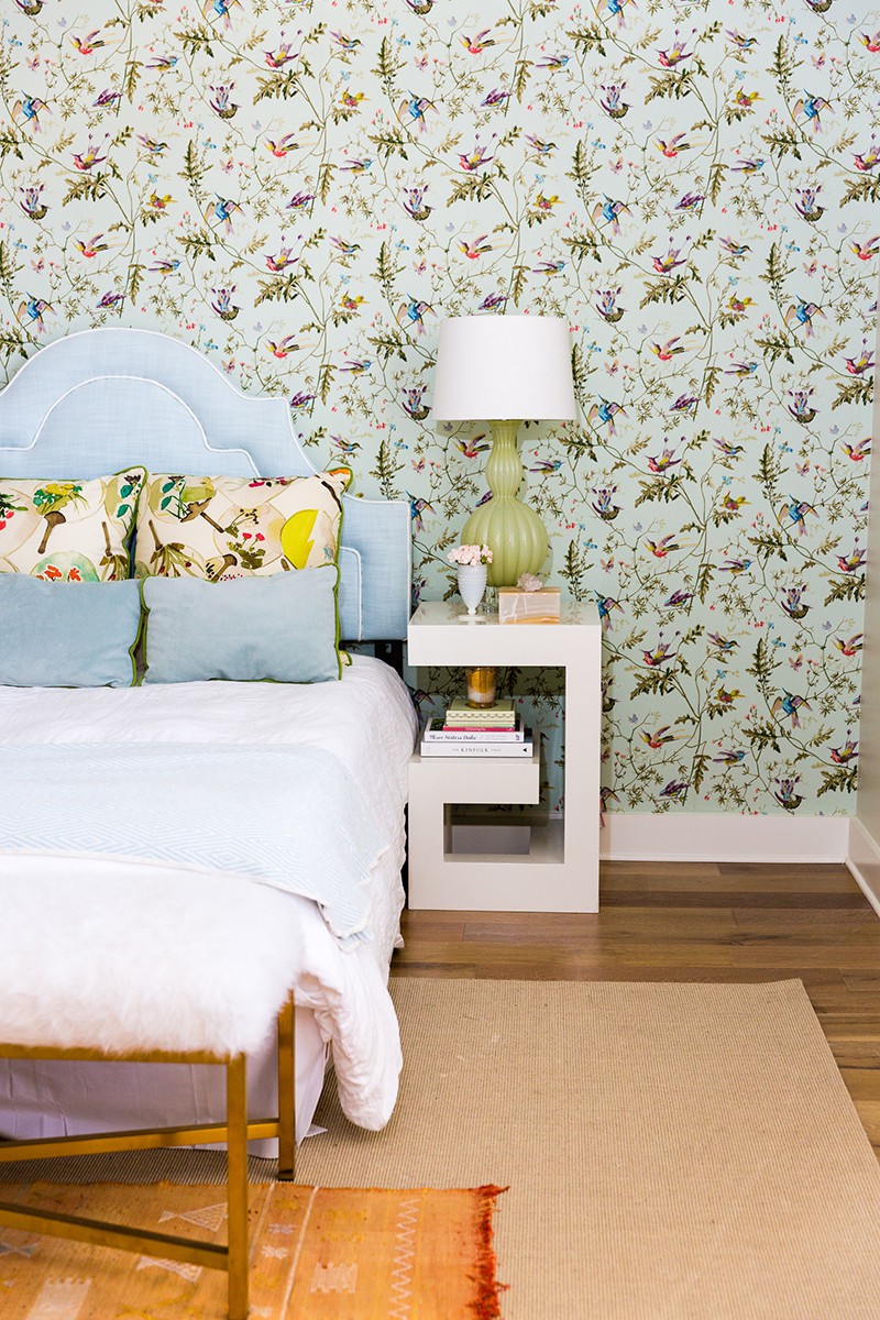Hình ảnh cận cảnh tường đầu giường phòng ngủ được trang trí giấy dán tường họa tiết hoa lá, chim muông