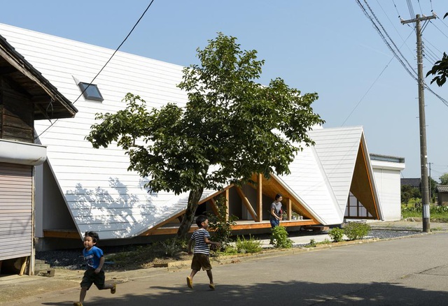 Hình ảnh cận cảnh một ngôi nhà màu trắng với mái sát đất, cửa hình tam giác độc đáo