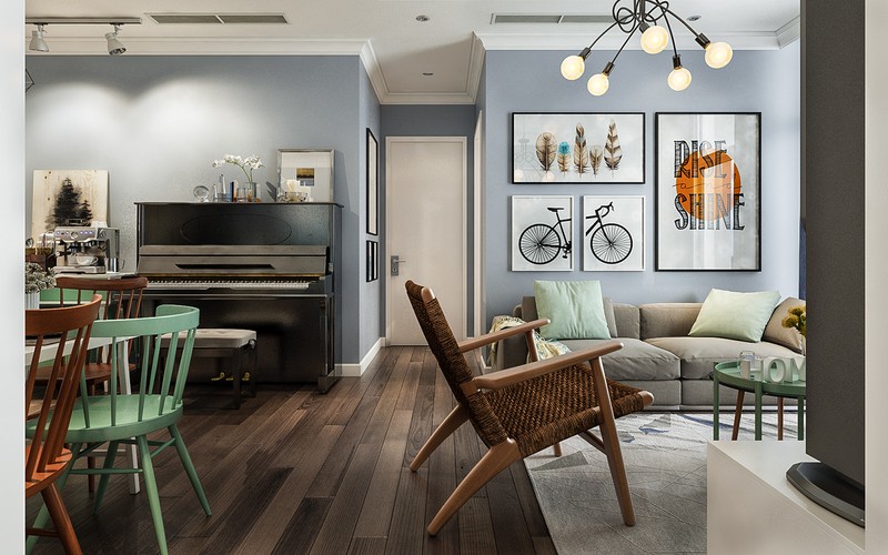 Hình ảnh một góc phòng khách liền kề phòng ăn trong căn hộ 80m2 với sàn lát gỗ sẫm màu,tranh treo tường, ghế ngồi màu sắc
