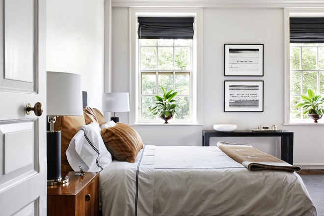 Hình ảnh phòng ngủ màu trắng chủ đạo với cửa sổ kính trong suốt, bệ cửa sổ là nơi đặt chậu cảnh xanh mướt.