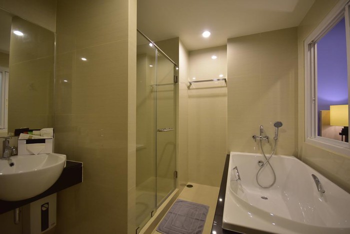 Hình ảnh phòng tắm rộng rãi gồm nhiều khu vực chức năng, phân tách bằng vách kính
