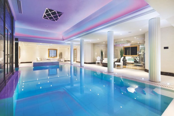Hình ảnh cận cảnh bể bơi bên tron biệt thự với nước trong ánh, ánh đèn LED màu tím
