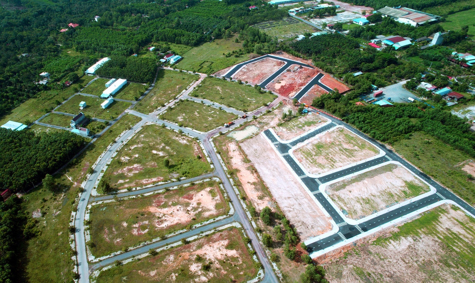 Hình ảnh một khu đất được phân lô bán nền nhìn từ trên cao với xung quanh lác đác các công trình nhà ở, xây dựng, rất nhiều cây xanh