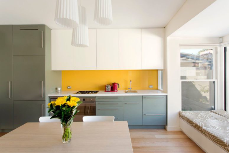 Hình ảnh tường chắn bếp màu vàng chanh nổi bật trên nền trắng, xanh dương chủ đạo của phòng bếp