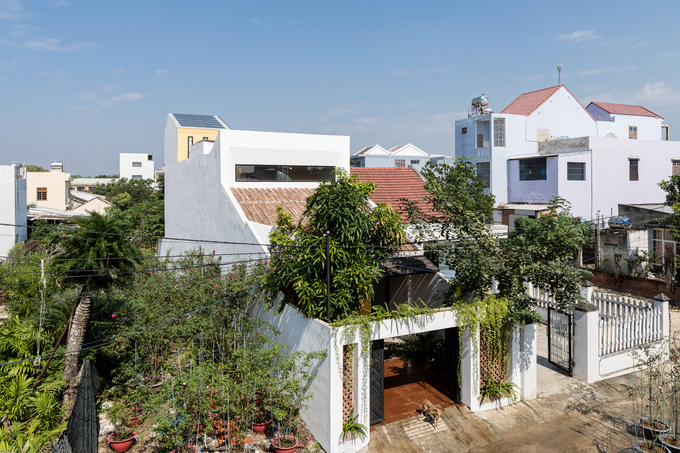Hình ảnh nhà 2 tầng ở Quảng Nam nhìn từ trên cao với cay xanh phủ mái, cổng sắt chắc chắn, tường bê tông mộc mạc