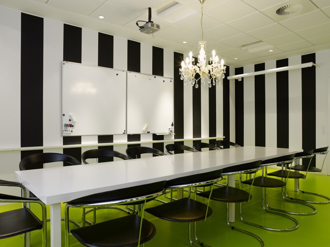 Hình ảnh một phòng ăn với bàn chữ nhật dài, 10 ghế kim loại bọc nệm, sàn nhà màu xanh lá