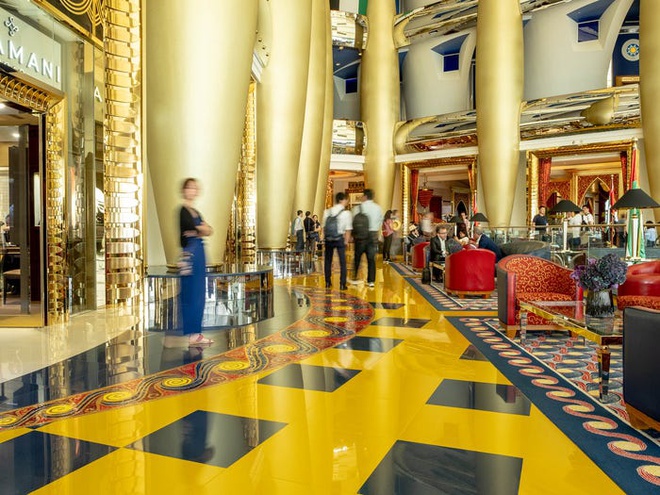 Hình ảnh toàn cảnh khu vực tiền sảnh của khách sạn 7 sao rộng rãi, được trang trí lộng lẫy với sàn nhà và rường cột màu vàng nổi bật; nội thất tinh xảo màu nghệ tây.