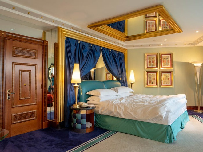 Hình ảnh phòng ngủ rộng rãi, ấn tượng với cửa gỗ tự nhiên, khung gương trên trần, giường nệm cao cấp