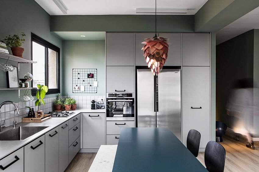 Hình ảnh phòng bếp ăn hiện đại với hệ tủ kệ lưu trữ màu sáng, kệ gắn tường, điểm xuyết bằng một số chậu cây gia vị xanh mướt.