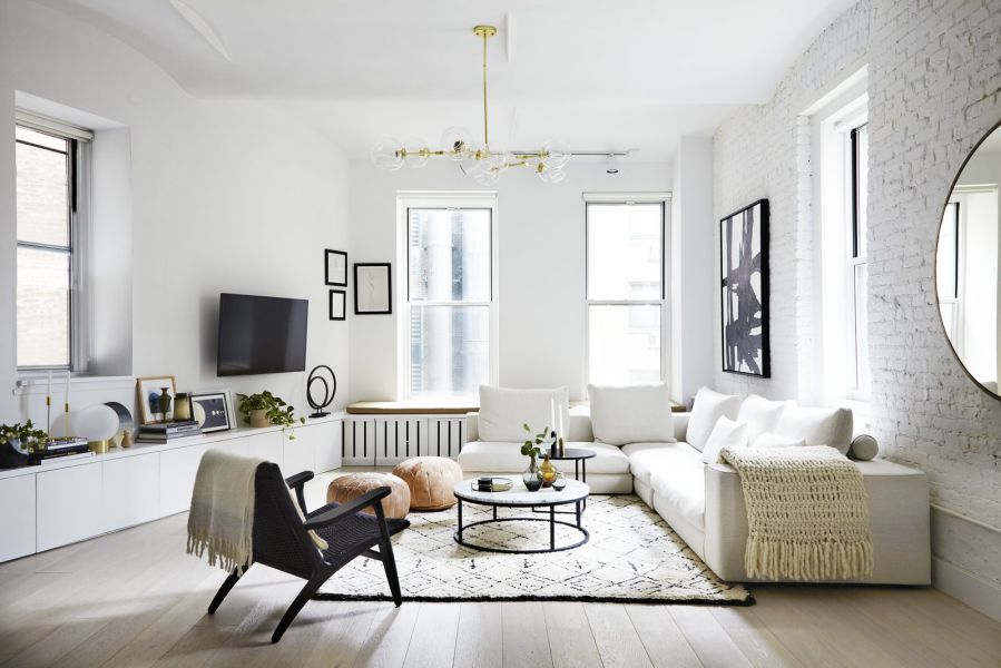 Hình ảnh phòng khách rộng rãi với sắc trắng chủ đạo cho tường, trần, sofa trong khi sắc đen điểm xuyết ở ghế thư giãn, khung bàn trà, khung tranh treo tường.