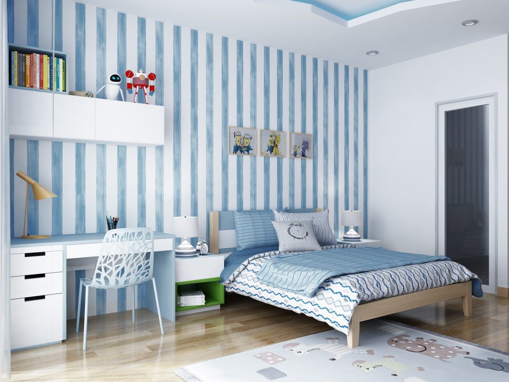 Hình ảnh bên trong một phòng ngủ với giấy dán tường kẻ sọc xanh trắng, ga gối cùng tông, kệ trắng gắn tường, cạnh đó là bàn học