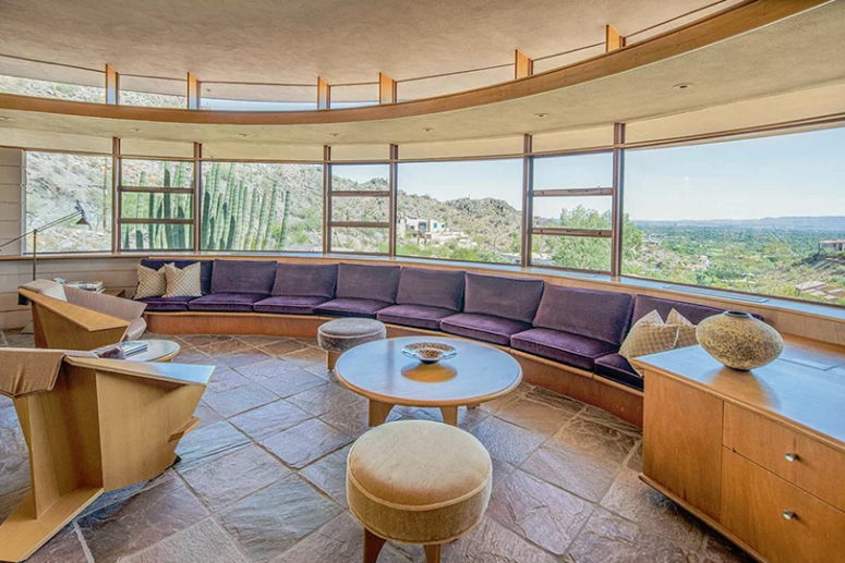 Hình ảnh không gian phòng khách rộng rãi với băng ghế cong bọc nệm màu tím oải hương đặt sát tường nhà