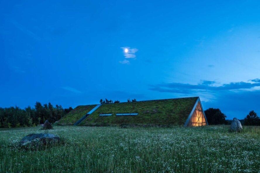 Hình ảnh mái nhà phủ kín cây xanh nhìn từ xa với cửa sổ kính mái lấy sáng tự nhiên