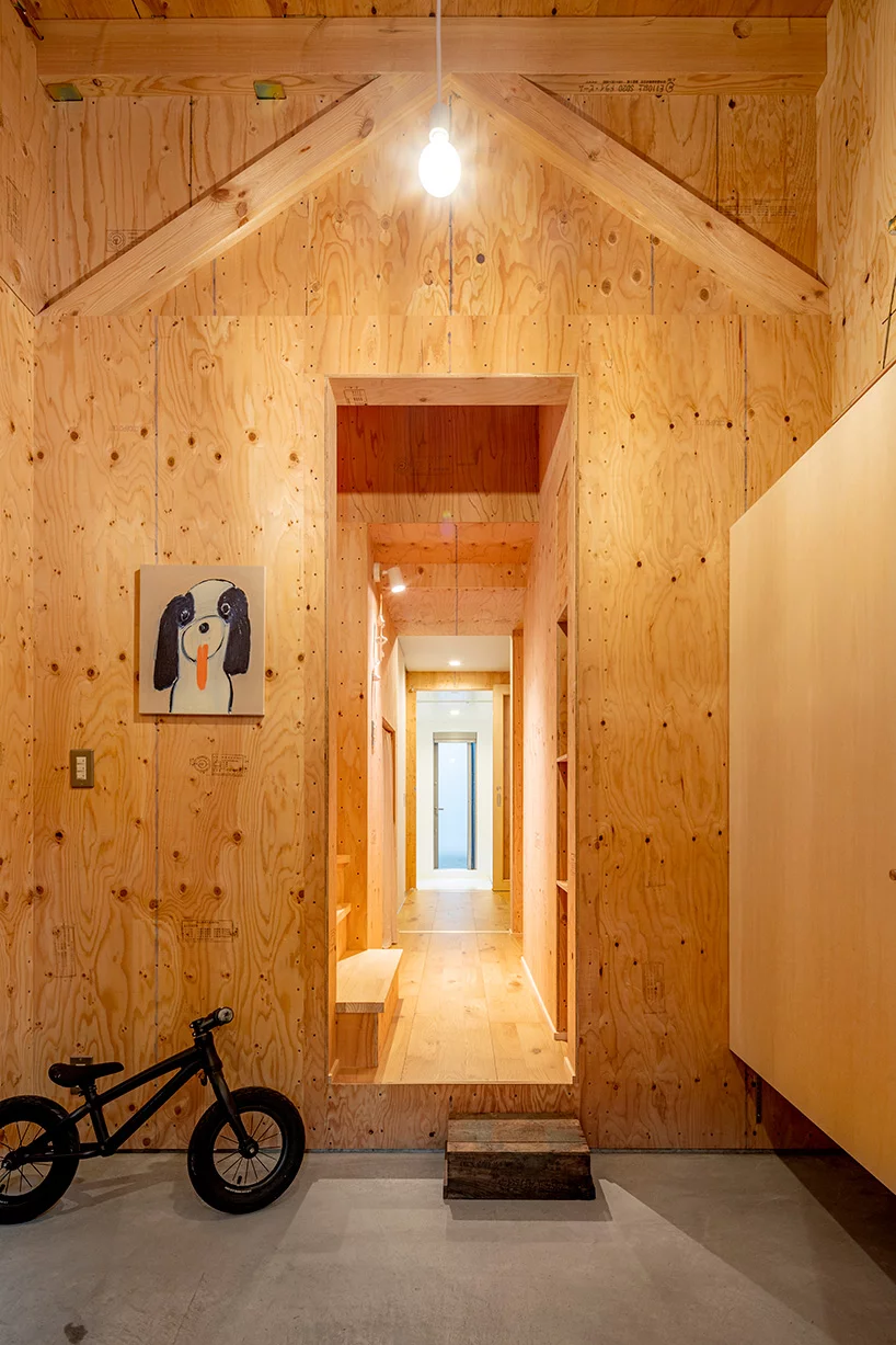 Hình ảnh lối vào nhà phố với tường, trần ốp gỗ, xe đạp