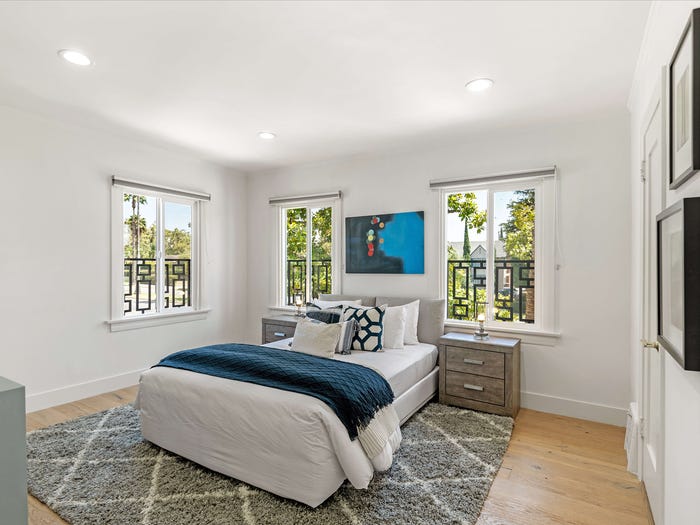 Hình ảnh một phòng ngủ có thiết kế đơn giản, sử dụng màu trắng chủ đạo, cửa sổ kính trong suốt lấy sáng tự nhiên