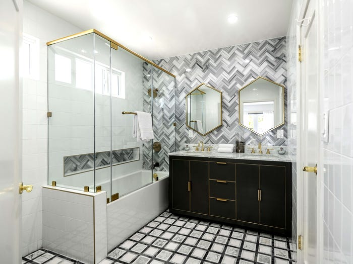 Hình ảnh phòng tắm với buồng tắm kính, khung gương mạ đồng, tủ lưu trữ màu đen hiện đại