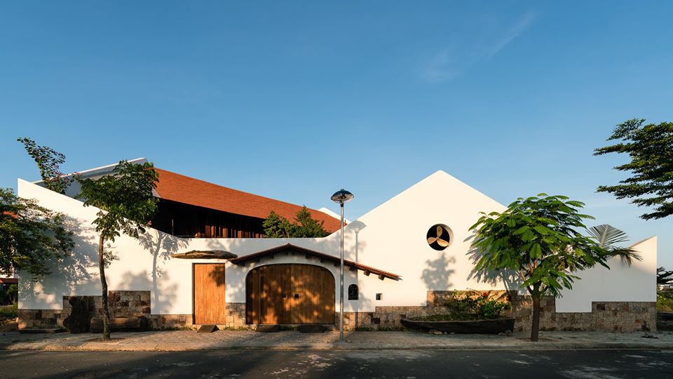 Hình ảnh toàn cảnh ngôi nhà gỗ ở Nha Trang gây ấn tượng thị giác mạnh bởi bức tường màu trắng vát xéo