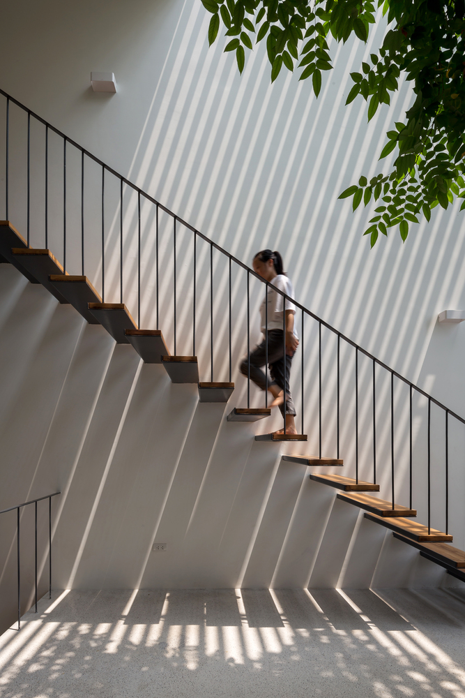 Hình ảnh một bé gái đang bước đi trên cầu thang nhà ống Hà Nội