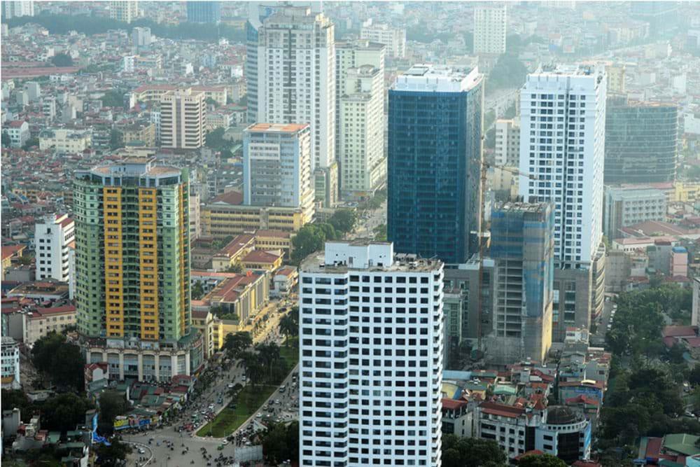 Hình ảnh một góc thành phố với những tòa nhà cao tầng xây dựng san sát nhau, xen kẽ với khu dân cư thấp tầng và cây xanh, đường sá