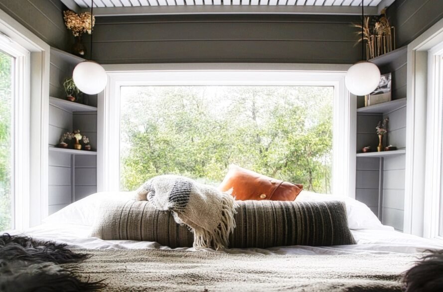 Hình ảnh một phòng ngủ master với giường ngủ đôi đặt cạnh cửa sổ kính lớn