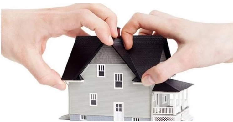 Hình ảnh cận cảnh hai bàn tay cùng bấu chặt mô hình một ngôi nhà, minh họa cho việc tranh chấp nhà đất khi nhờ người khác đứng tên mua hộ