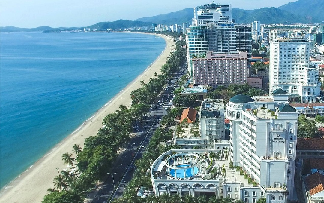 Hình ảnh một góc thành phố ven biển với các tòa nhà cao tầng xen lẫn cây xanh, nơi bất động sản nghỉ dưỡng Việt Nam